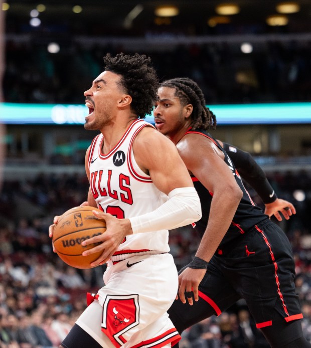 Chicago Bulls guard Tre Jones goes for a layup over Toronto Raptors forward Jonathan Mogbo in the second half of a game against the Toronto Raptors at the United Center in Chicago on Feb. 19, 2026. (Josh Boland/Chicago Tribune)