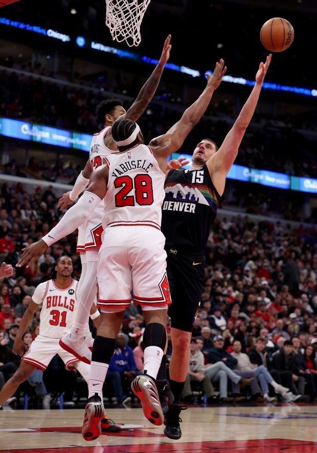 Denver Nuggets center Nikola Jokić (15) puts up a shot over Chicago Bulls guard Anfernee Simons and center/forward Guerschon Yabusele (28) in the first half of a game at the United Center in Chicago on Feb. 7, 2026. (Chris Sweda/Chicago Tribune)