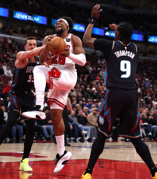 Chicago Bulls forward Guerschon Yabusele (28) drives through the defense of Detroit Pistons forward Duncan Robinson (55) and guard/forward Ausar Thompson (9) in the first half of a game at the United Center in Chicago on Feb. 21, 2026. (Chris Sweda/Chicago Tribune)