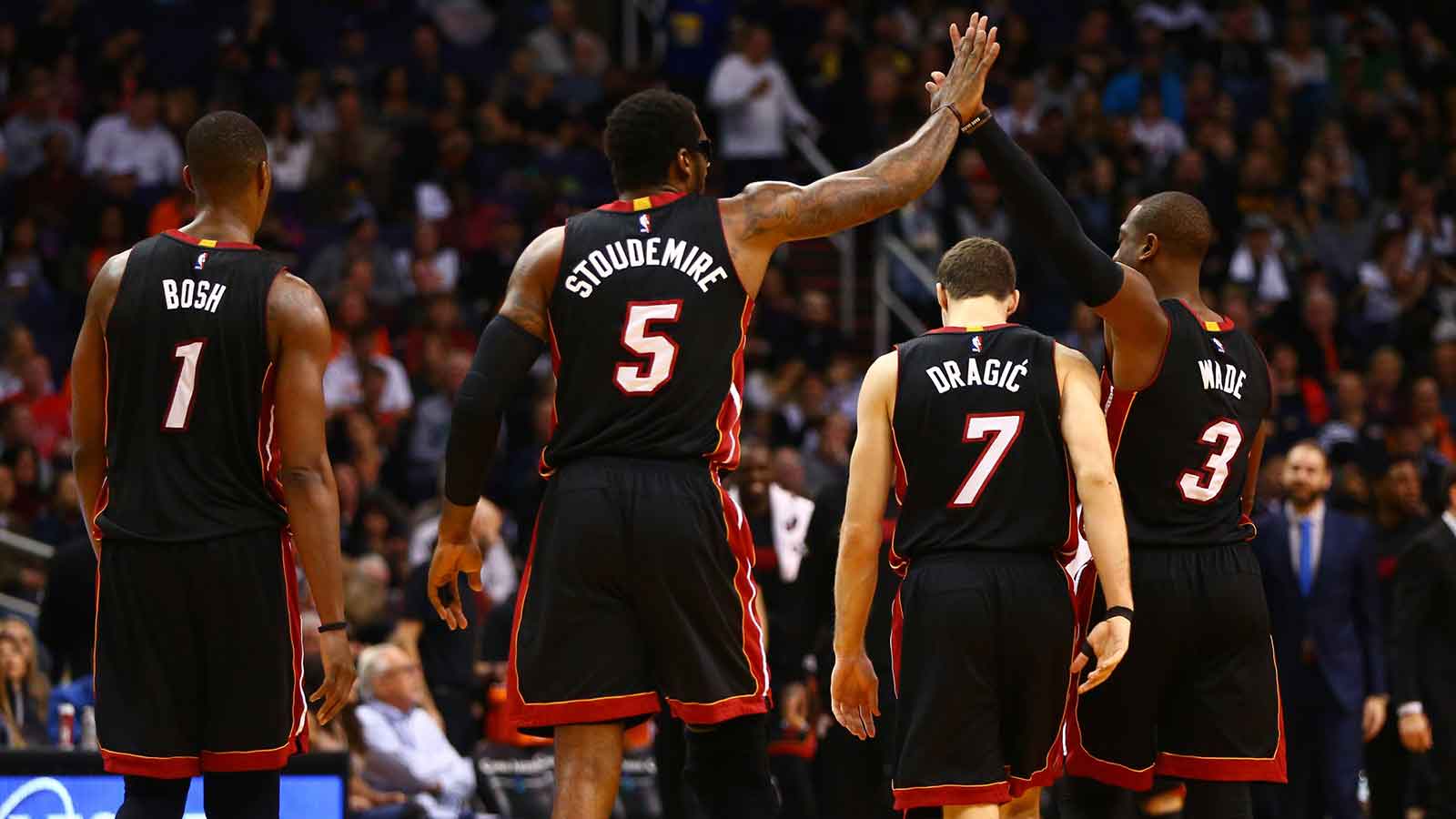 Miami Heat forward Chris Bosh (1), forward Amar'e Stoudemire (5), guard Goran Dragic (7) and guard Dwyane Wade (3) celebrate a play as they head to the bench in the second quarter against the Phoenix Suns at Talking Stick Resort Arena. 