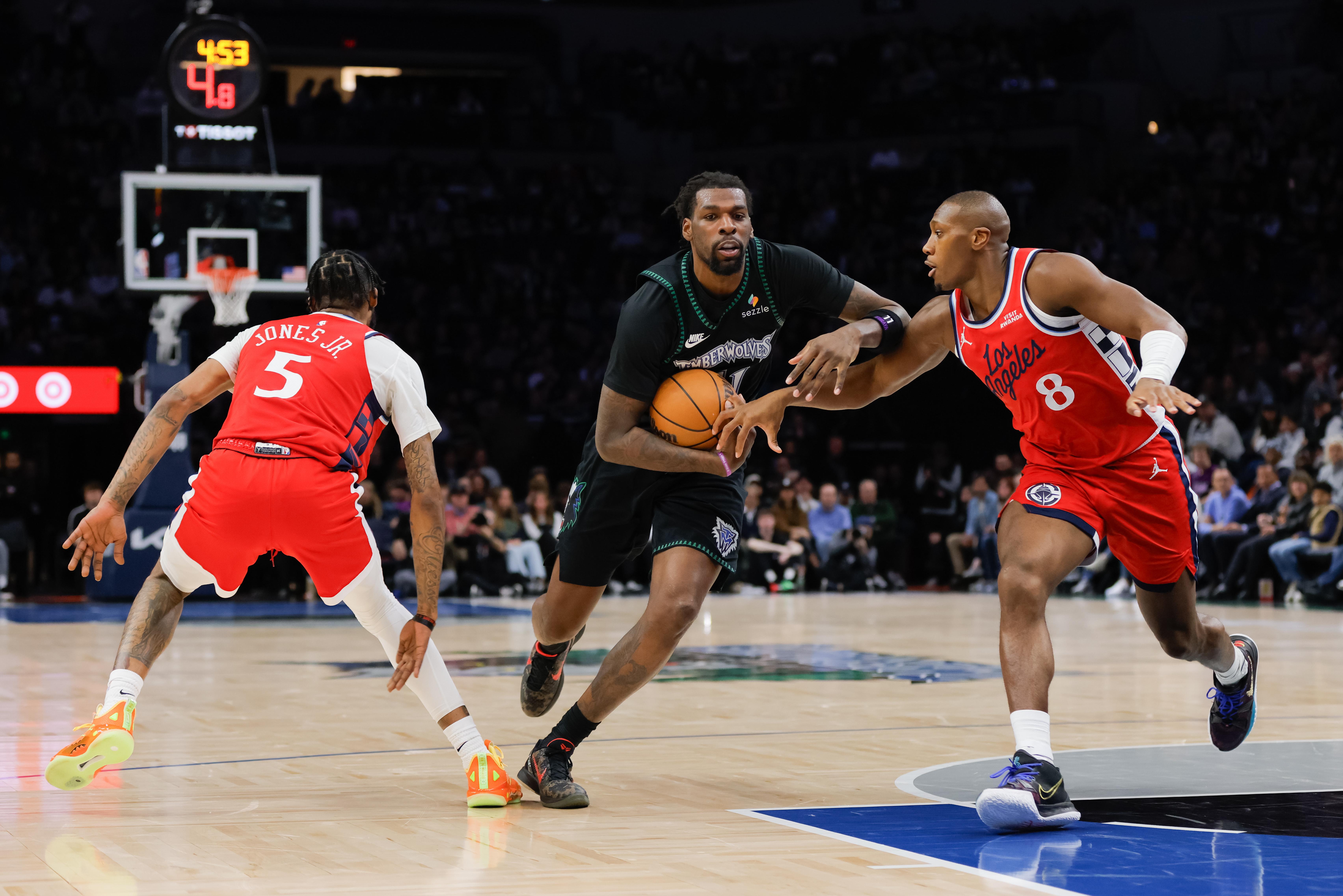 Minnesota Timberwolves center Naz Reid, center, drives to the basket...