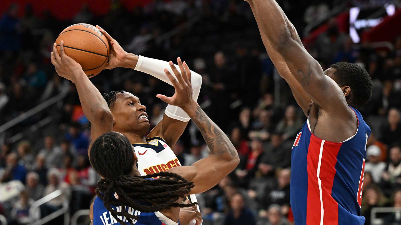 Denver Nuggets guard Peyton Watson (8) drives to the basket against Detroit Pistons guard Daniss Jenkins (24) and Detroit Pistons center Jalen Duren (0) in the third quarter at Little Caesars Arena.