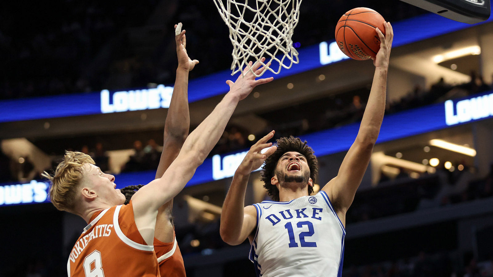 Nov 4, 2025; Charlotte, North Carolina, USA; Duke Blue Devils forward Cameron Boozer (12) goes for a lay up against the Texas Longhorns during the first half of the Dick Vitale’s Invitational game at Spectrum Center. Mandatory Credit: Cory Knowlton-Imagn Images