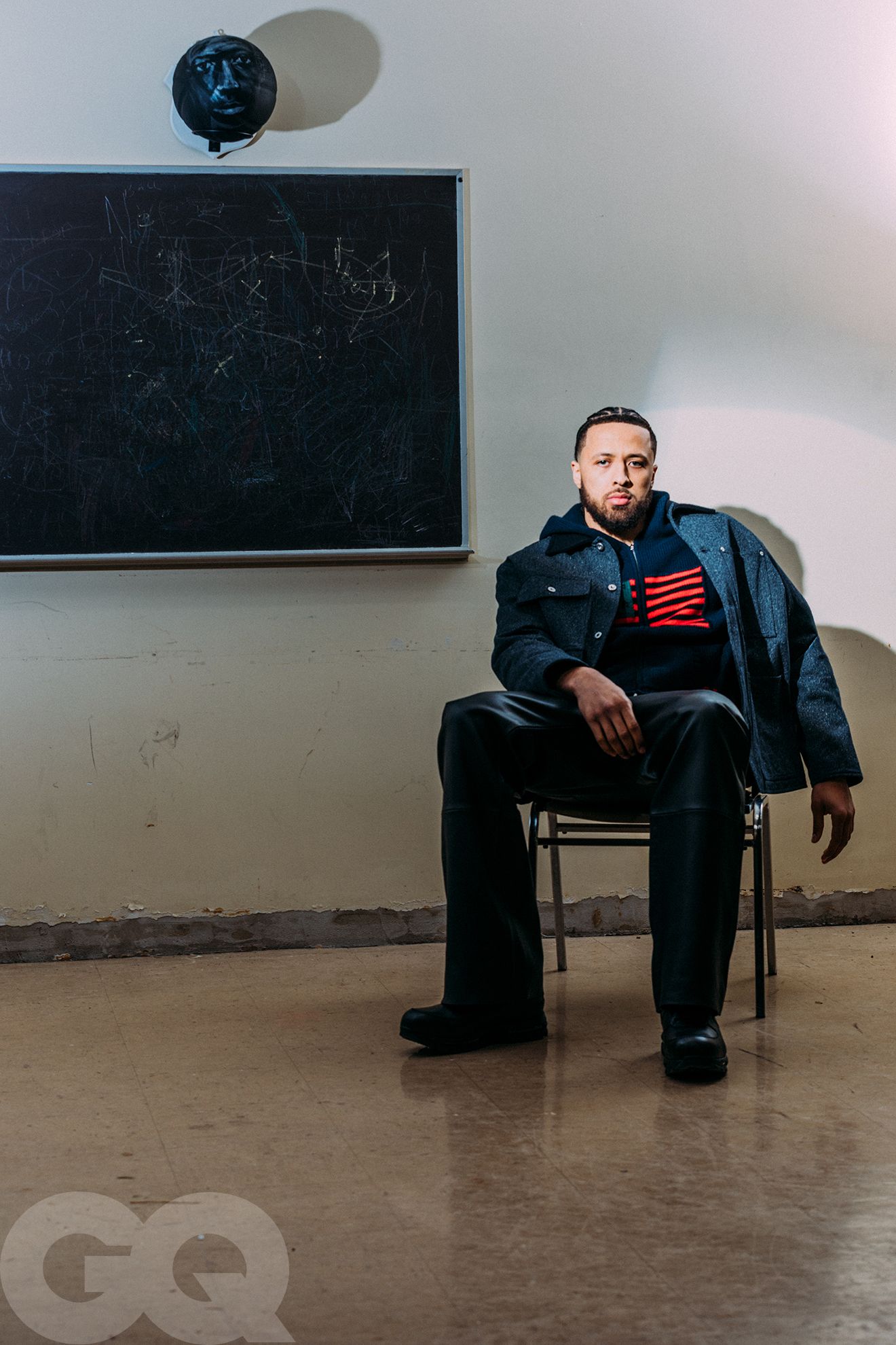 Image may contain Person Sitting Adult Blackboard Clothing Coat Footwear and Shoe