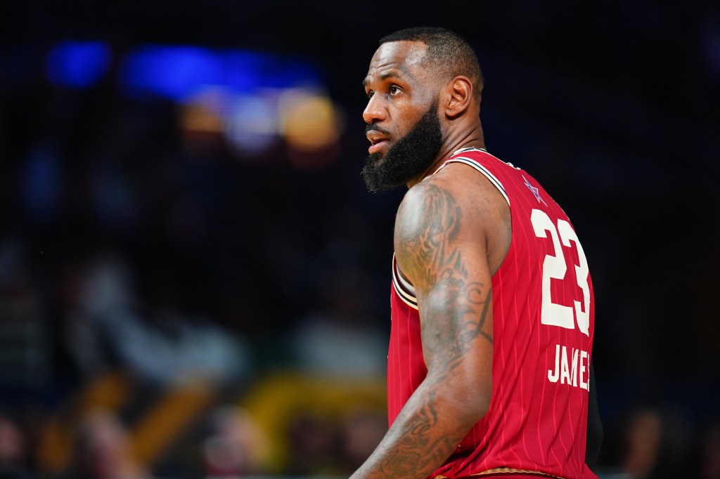 LeBron James in a red jersey looks on during the NBA All-Star Game.