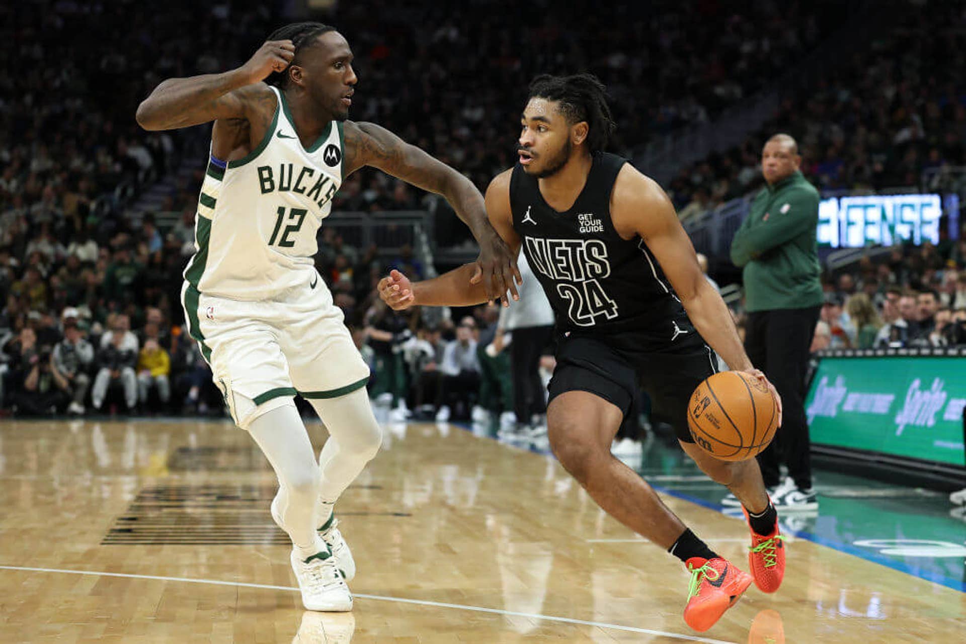 Cam Thomas attempts to dribble past Taurean Prince during a Nets-Bucks.