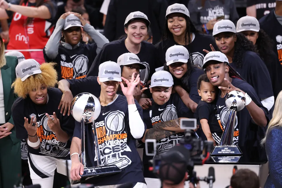 PHOENIX, ARIZONA - OCTOBER 10: A'ja Wilson #22 of the Las Vegas Aces holds the championship trophy and poses with teammates after winning Game Four of the 2025 WNBA Playoffs finals at Mortgage Matchup Center on October 10, 2025 in Phoenix, Arizona. The Las Vegas Aces defeat the Phoenix Mercury 97-86 to win the championship. NOTE TO USER: User expressly acknowledges and agrees that, by downloading and or using this photograph, User is consenting to the terms and conditions of the Getty Images License Agreement.  (Photo by Chris Coduto/Getty Images)