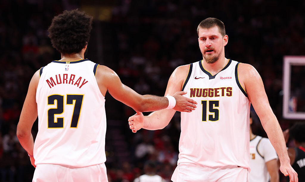 HOUSTON, TEXAS - NOVEMBER 21: Nikola Jokić #15 and Jamal Murray #27 of the Denver Nuggets react du...