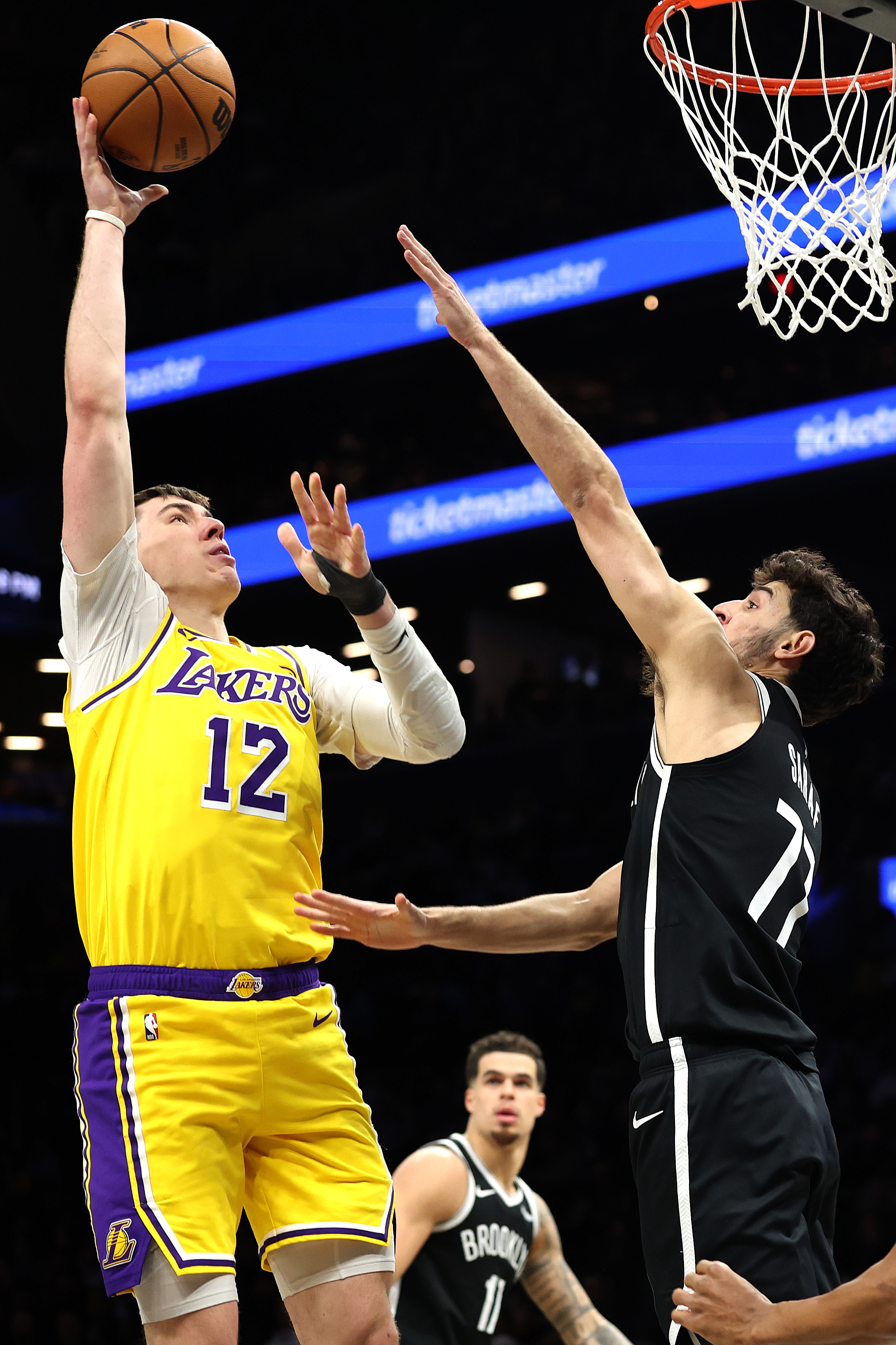 Lakers forward Jake LaRavia takes a shot in front of...