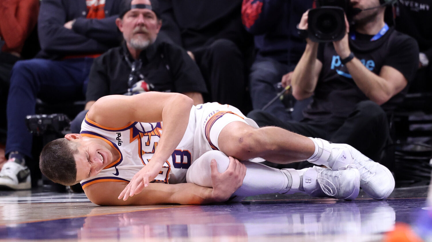 Grayson Allen #8 of the Phoenix Suns reacts after an apparent injury during the second half against...