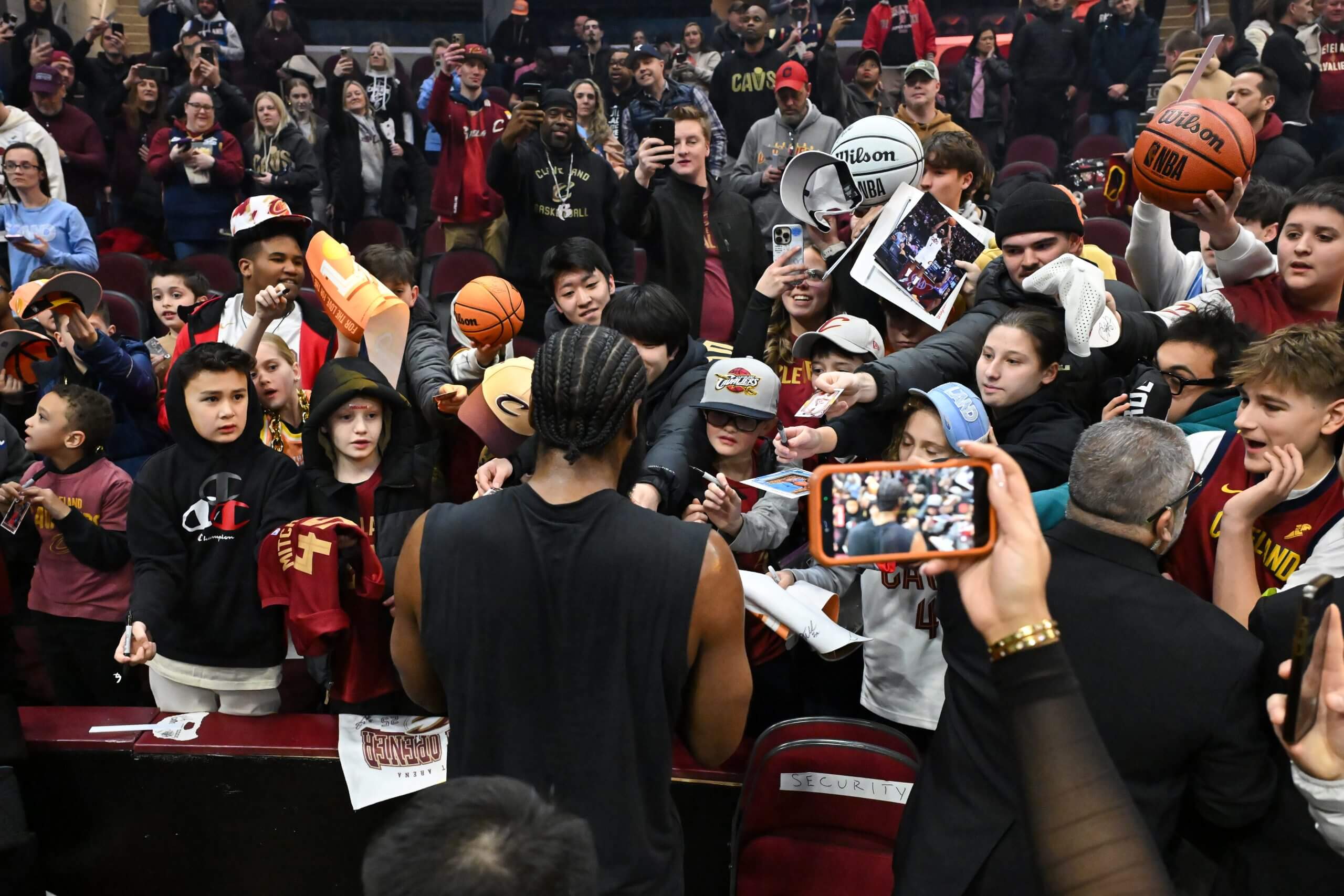 James Harden, with his back to the camera, signs autographs for a crowd holding basketballs and photos Wednesday night before the Cavaliers' game against the Wizards in Cleveland.