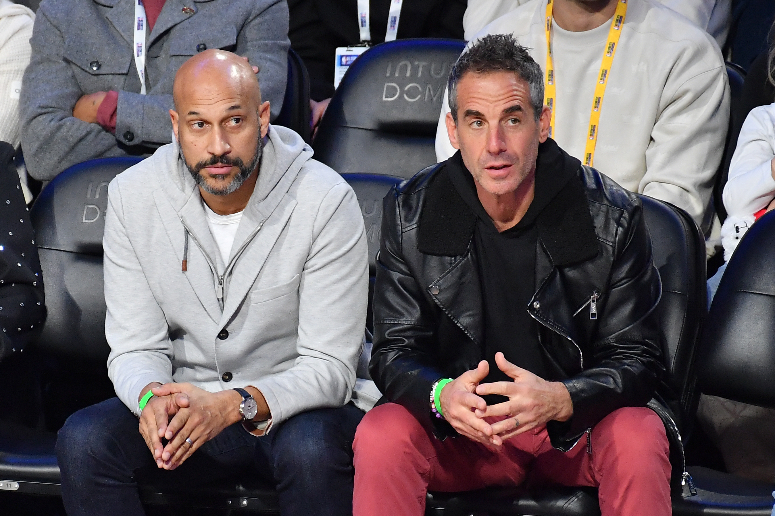 Actor Keegan-Michael Key, left, watches from a courtside seat during...