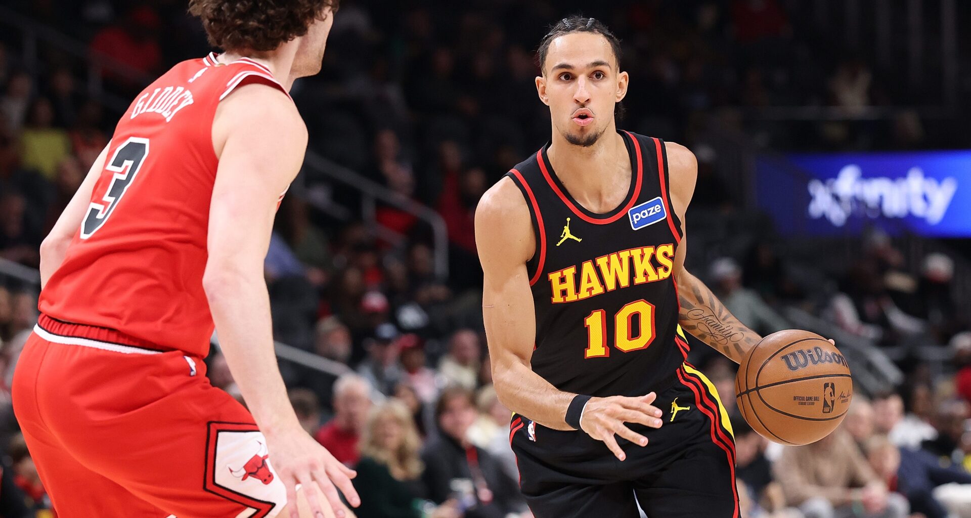 ATLANTA, GEORGIA - DECEMBER 21: Zaccharie Risacher #10 of the Atlanta Hawks drives against Josh Giddey #3 of the Chicago Bulls during the first quarter at State Farm Arena on December 21, 2025 in Atlanta, Georgia