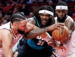 Portland Trail Blazers center Robert Williams III, middle, grabs the ball against Phoenix Suns forward Dillon Brooks, left, and center Mark Williams during the second half of an NBA basketball game Tuesday, Feb. 3, 2026, in Portland, Ore.