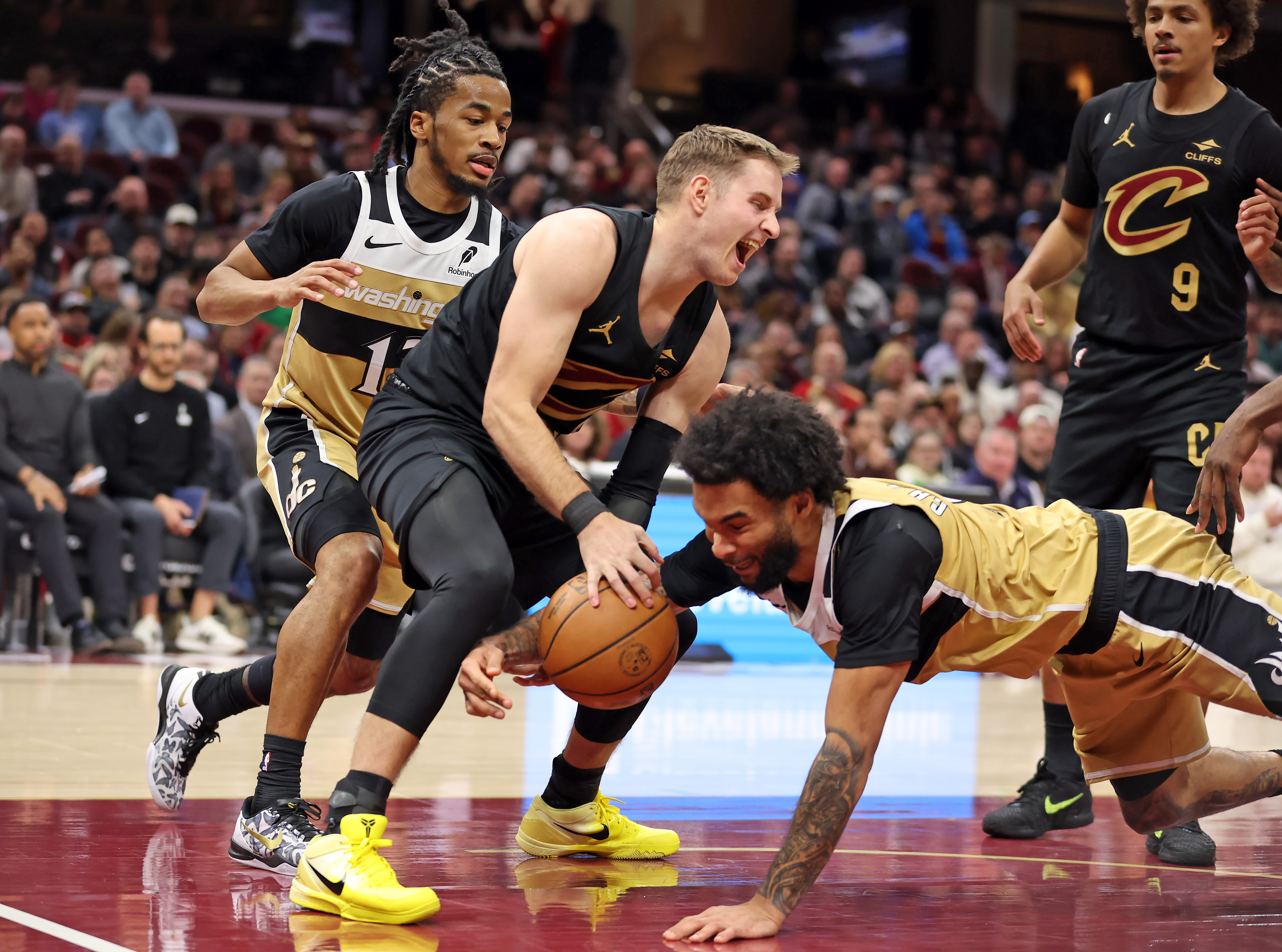 Cleveland Cavaliers guard Sam Merrill and Washington Wizards forward Justin Champagnie battle for a loose ball in the second half of play. 