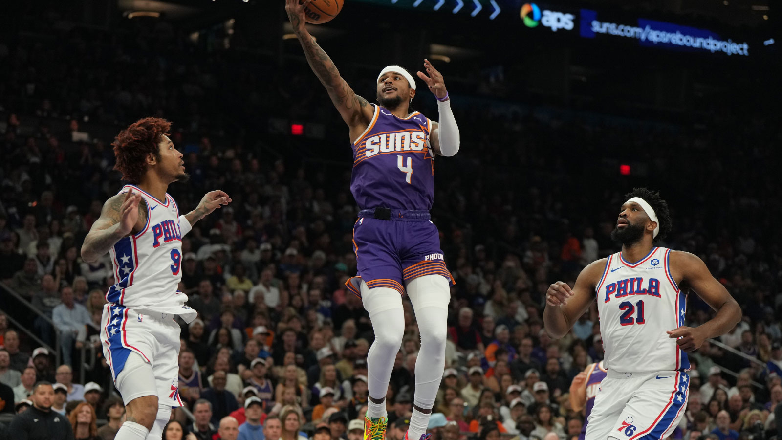Phoenix Suns guard Jalen Green (4) drives between Philadelphia 76ers guard Kelly Oubre Jr. (9) and center Joel Embiid (21) during the first half of an NBA game at Mortgage Matchup Center.