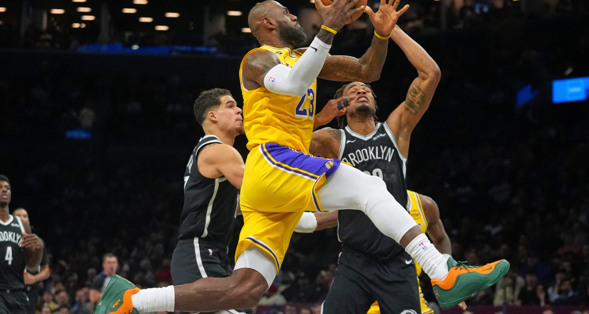 Los Angeles Lakers' LeBron James, center, drives past Brooklyn Nets' Nic Claxton, right, and Michael Porter Jr. during the first half of an NBA basketball game Tuesday, Feb. 3, 2026, in New York. (AP Photo/Frank Franklin II)