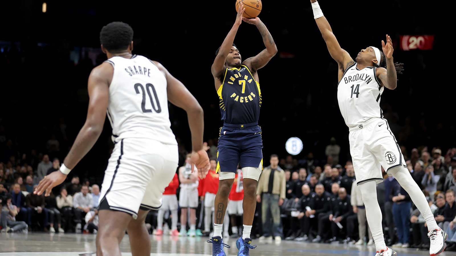 Indiana Pacers guard Kam Jones (7) shoots the go-ahead three point shot against Brooklyn Nets guard Terance Mann (14) and center Day'ron Sharpe (20) during the fourth quarter at Barclays Center.
