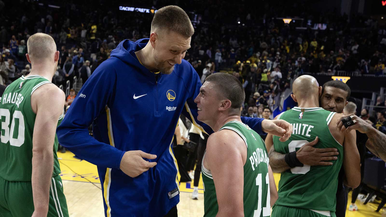 Golden State Warriors center Kristaps Porzingis (left) shares a laugh with Boston Celtics guard Payton Pritchard (11) following their game at Chase Center.