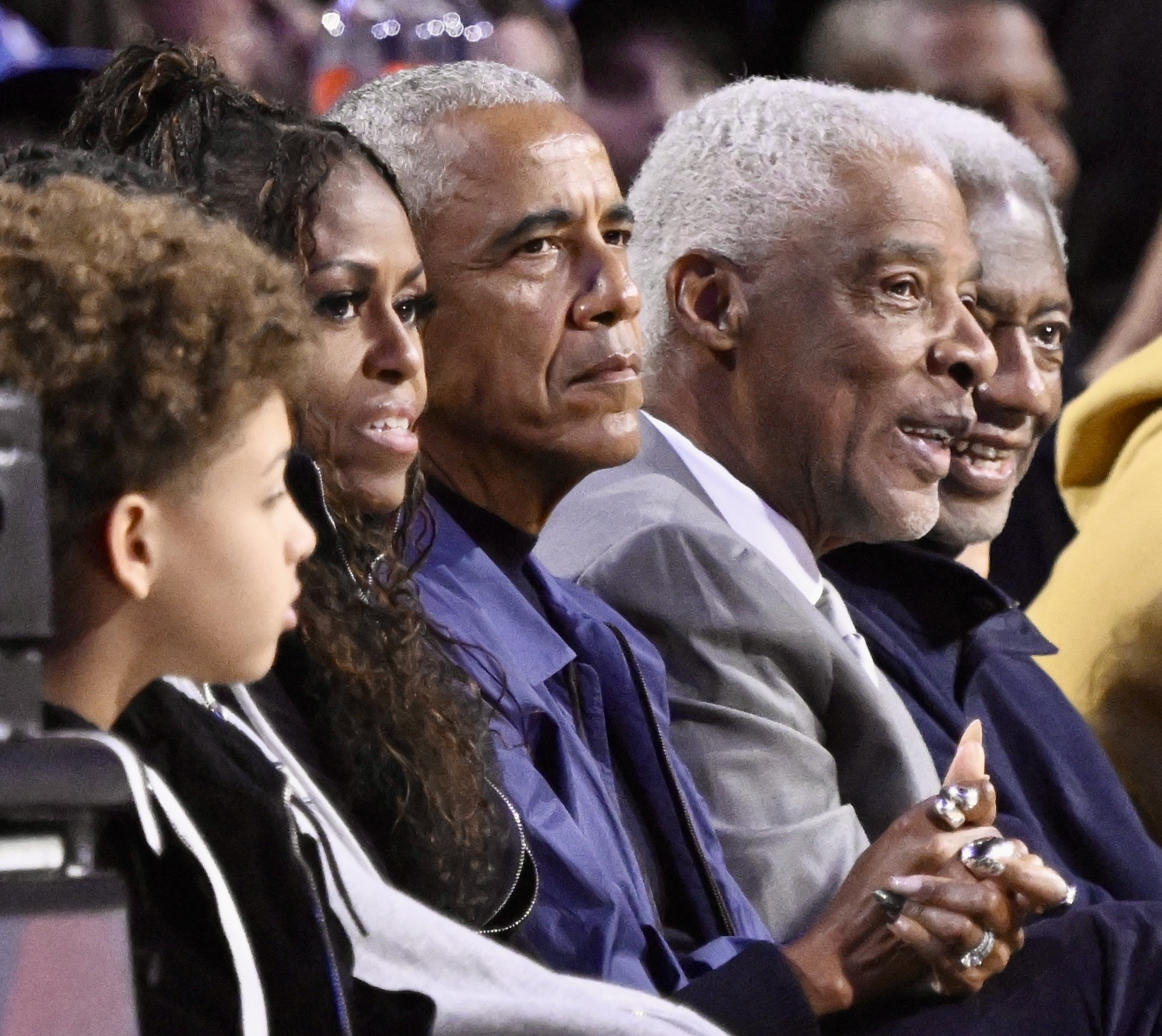 Former President Barack Obama, center, sits with his wife, Michelle...