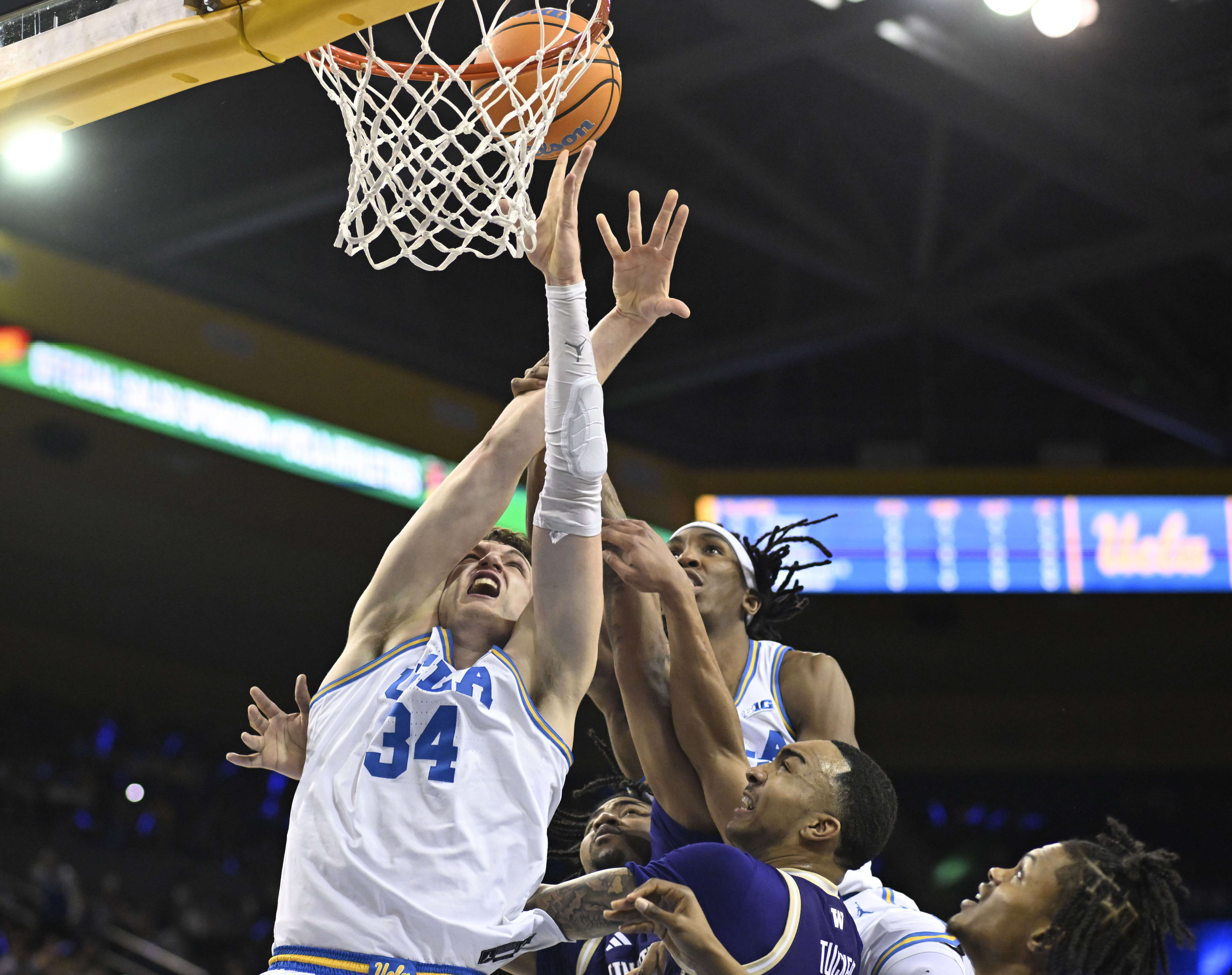 Forward Tyler Bilodeau #34 of the UCLA Bruins reaches for...