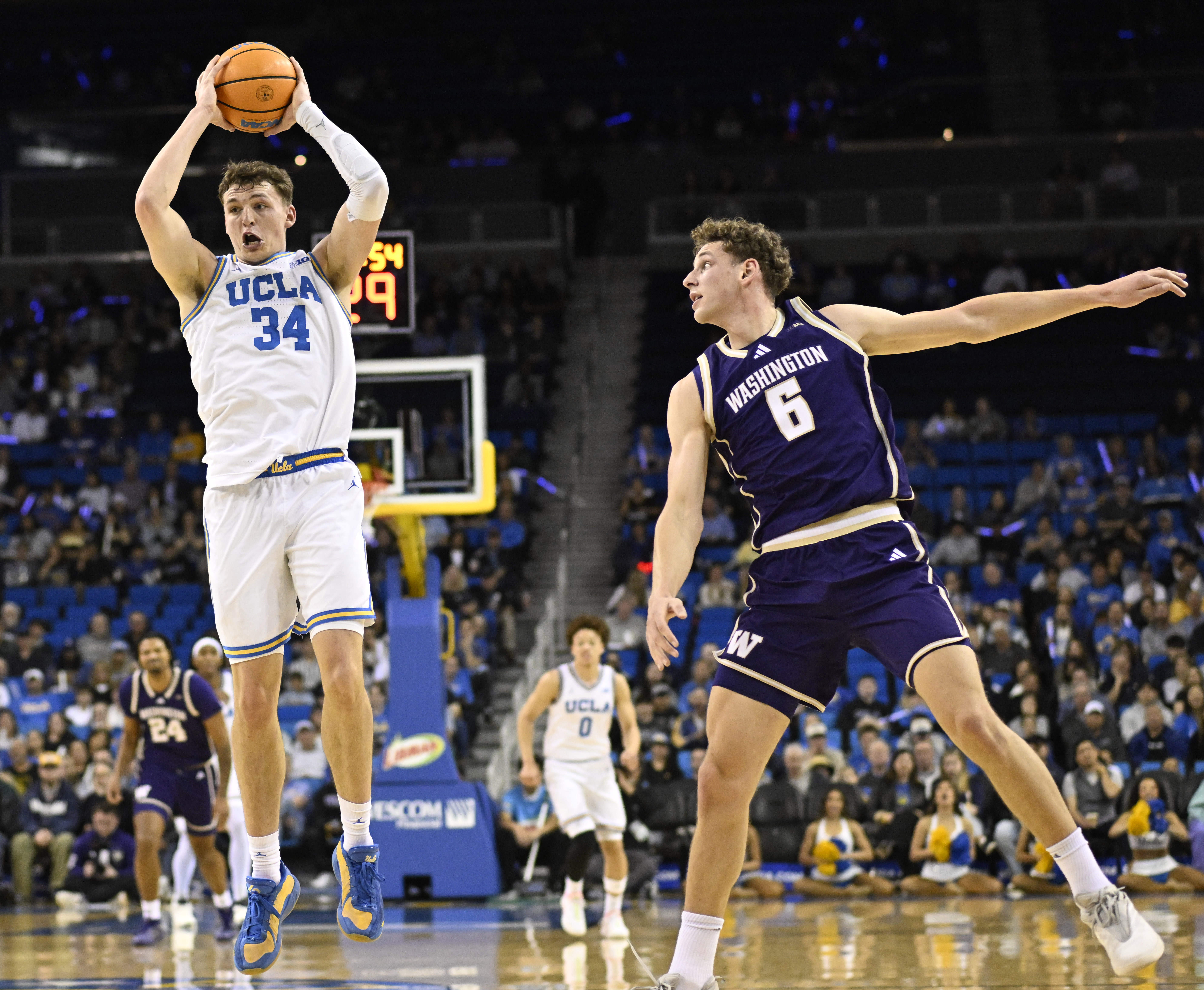 Forward Tyler Bilodeau #34 of the UCLA Bruins reaches for...