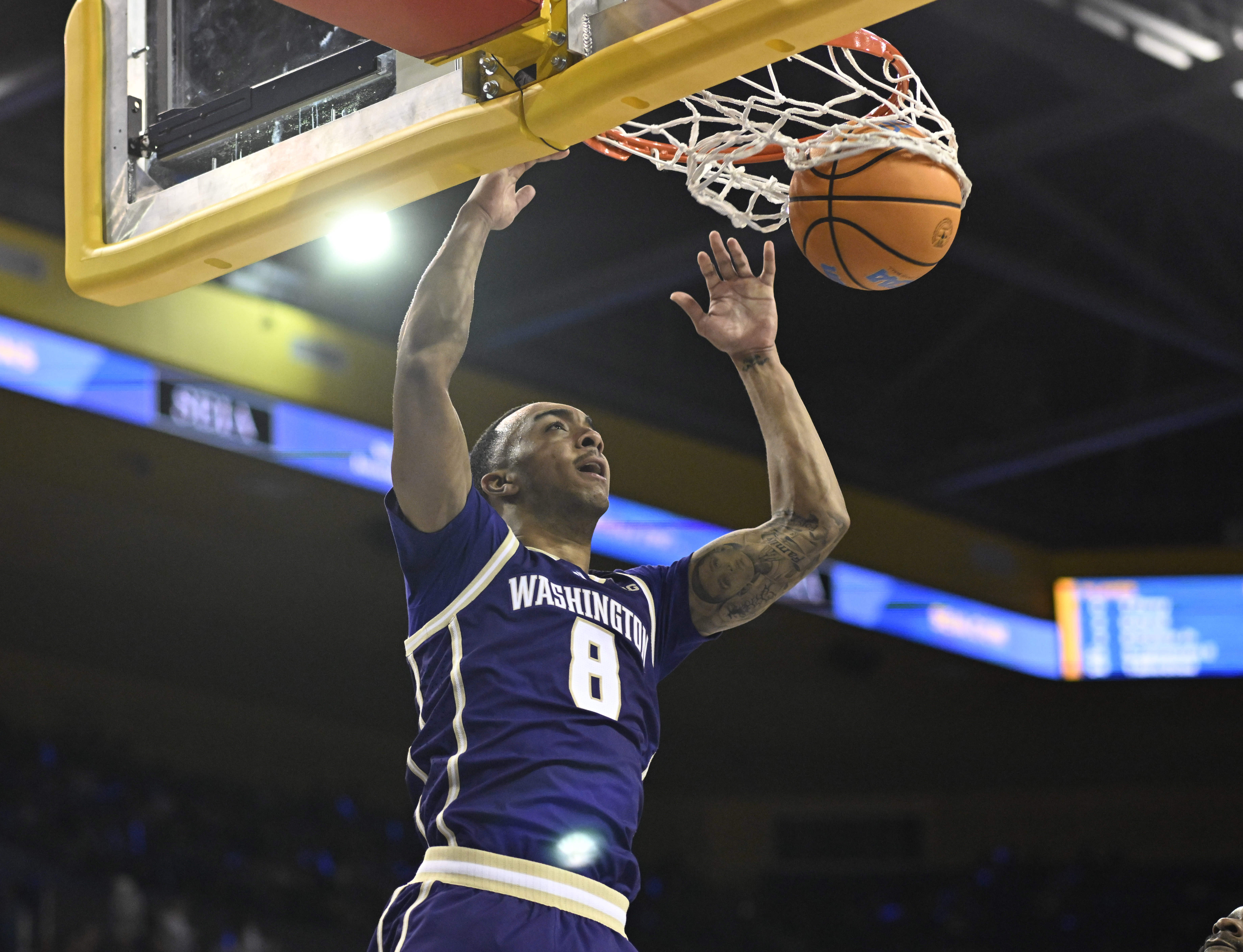 Forward Bryson Tucker #8 of the Washington Huskies slam dunks...