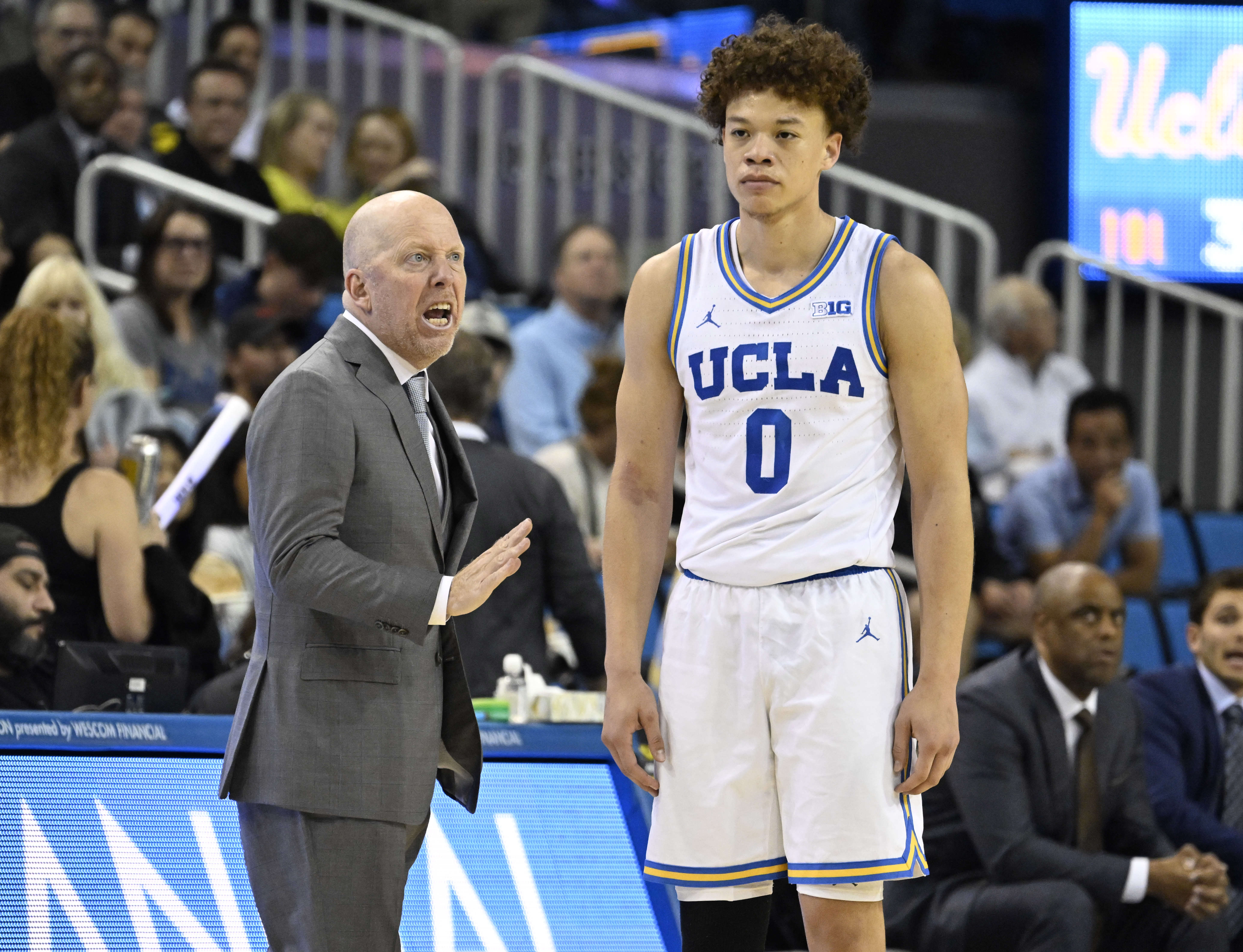 Head coach Mick Cronin of the UCLA Bruins talks with...