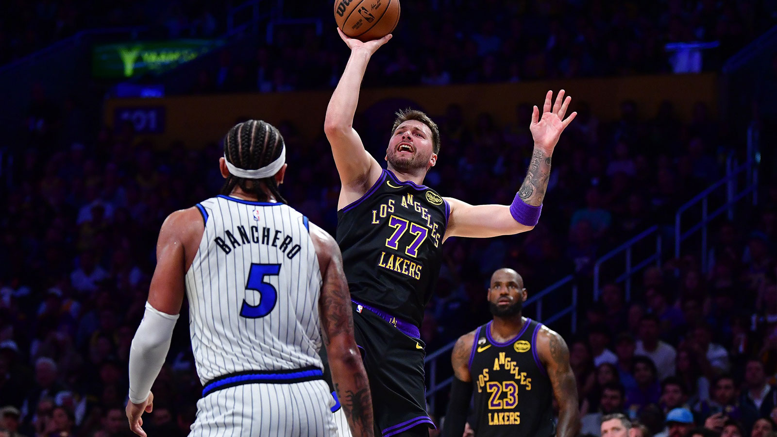 Los Angeles Lakers guard Luka Doncic (77) shoots against Orlando Magic forward Paolo Banchero (5) during the second half at Crypto.com Arena.