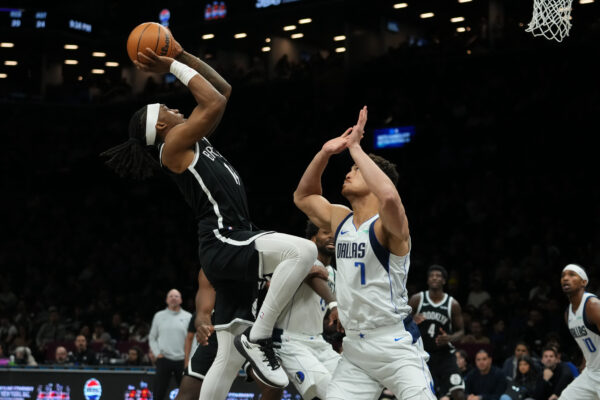 Dallas Mavericks' Dwight Powell (7) defends Brooklyn Nets' Terance Mann (14) during the second half of an NBA basketball game Tuesday, Feb. 24, 2026, in New York. (AP Photo/Frank Franklin II)