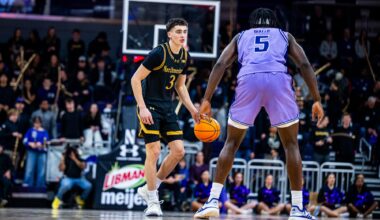 A player in black dribbles the ball up the court.