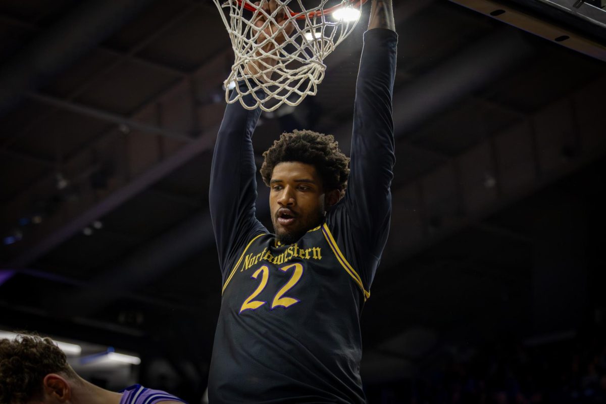 A Northwestern player hangs off the rim after a big dunk. 