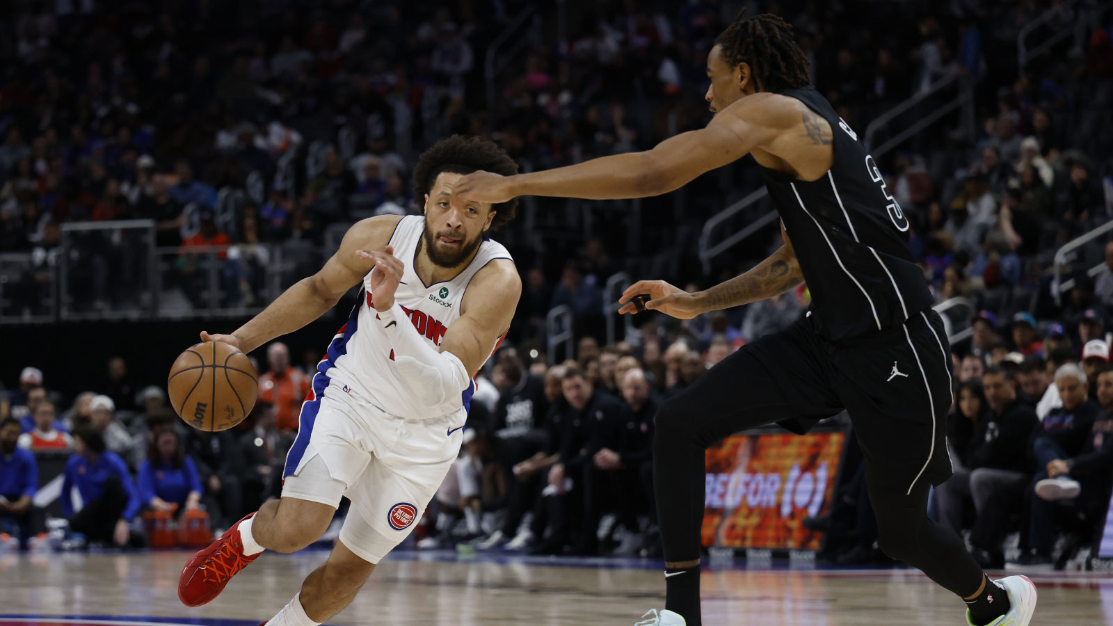 Pistons guard Cade Cunningham (2) dribbles defended by Brooklyn Nets guard Ben Saraf (77) in the second half at Little Caesars Arena