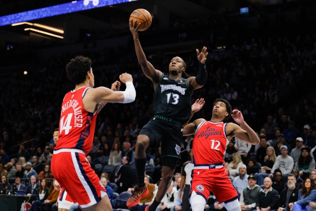Minnesota Timberwolves guard Ayo Dosunmu (13) goes up to shoot while Los Angeles Clippers center Yanic Konan Niederhauser (14) and guard Cam Christie (12) defend during the first half of an NBA basketball game, Sunday, Feb. 8, 2026, in Minneapolis. (AP Photo/Bailey Hillesheim)