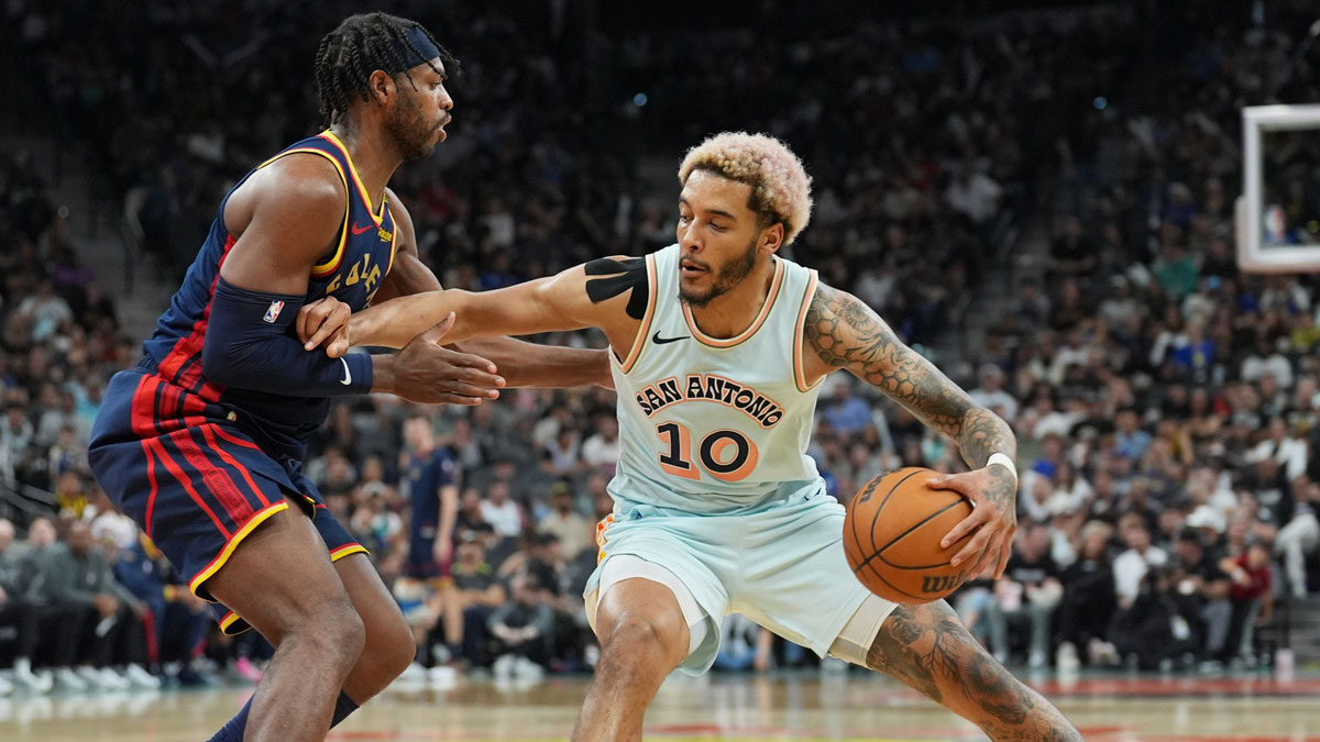 San Antonio Spurs forward Jeremy Sochan (10) dribbles against Golden State Warriors guard Buddy Hield (7) in the second half at Frost Bank Center.