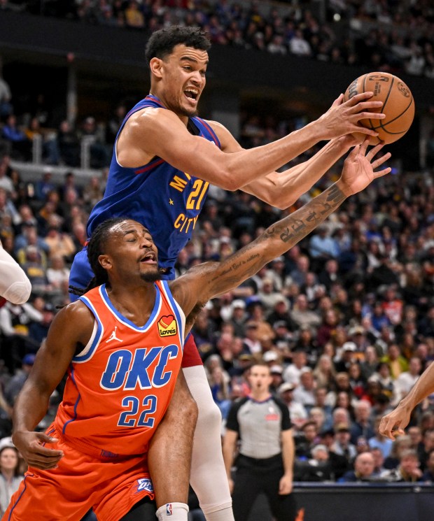 Spencer Jones (21) of the Denver Nuggets grabs a rebound over Cason Wallace (22) of the Oklahoma City Thunder during the first quarter at Ball Arena in Denver, Colorado on Sunday, February 1, 2026. (Photo by AAron Ontiveroz/The Denver Post)