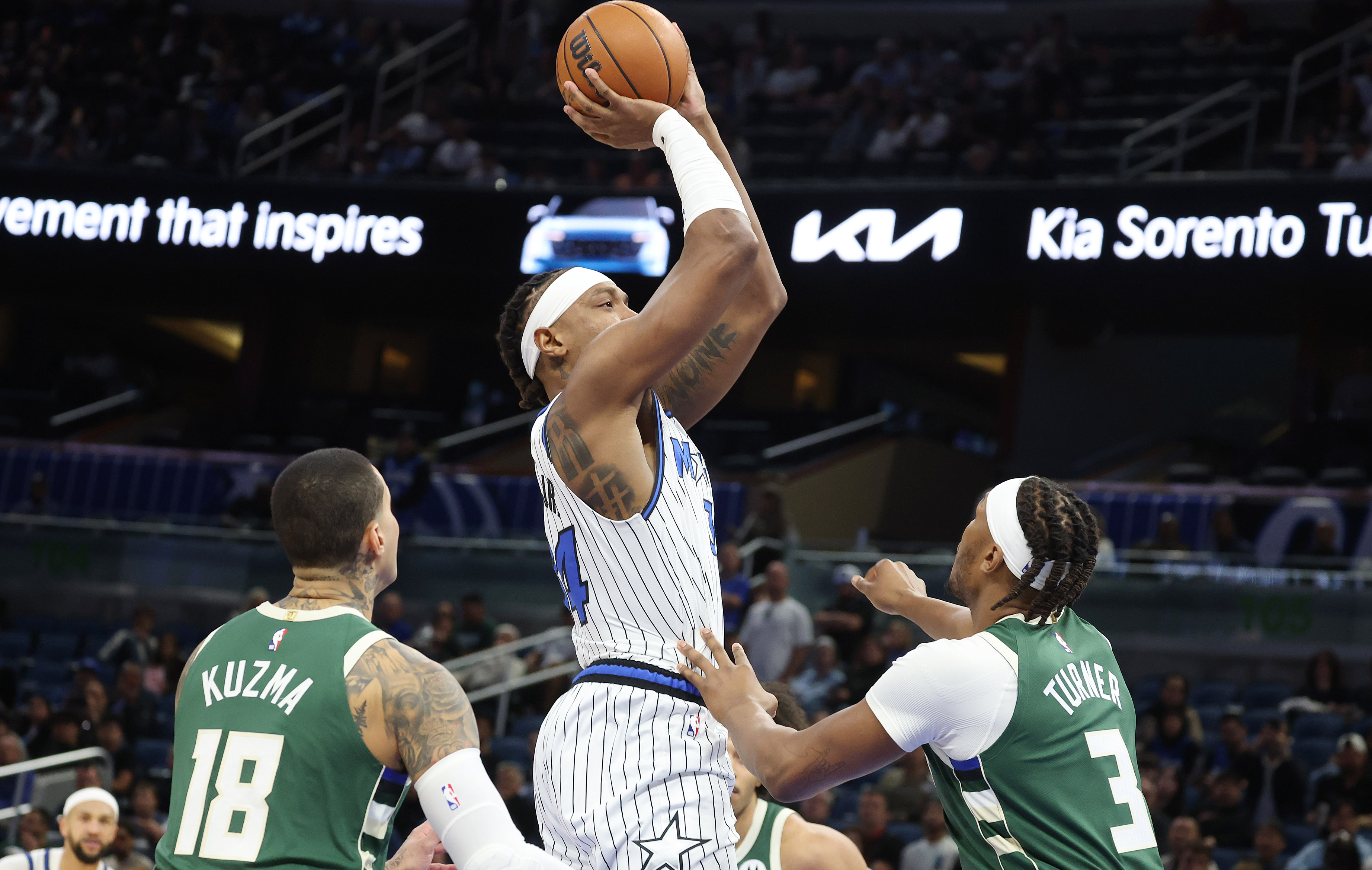 Orlando forward Paolo Banchero (middle) shoots between Milwaukee forward Kyle...