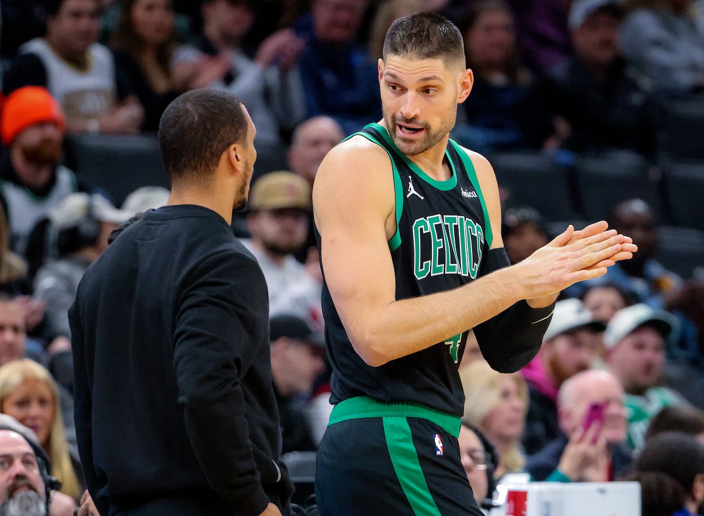 Celtics coach Joe Mazzulla has a few words with his newest charge, center Nikola Vucevic, before he enters his first game in Boston black and green.