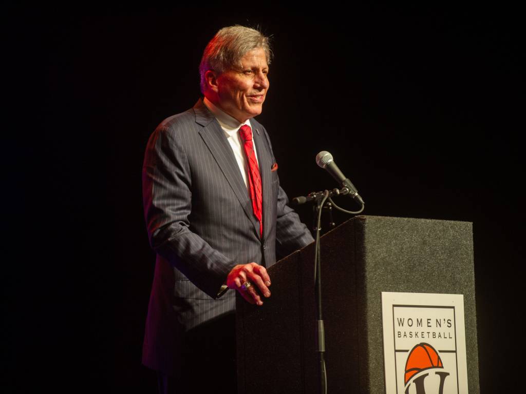 Doug Bruno speaks at a podium with the Women's Basketball Hall of Fame logo on it