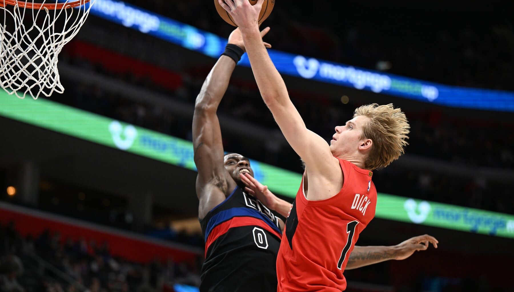 Jan 11, 2025; Detroit, Michigan, USA; Toronto Raptors guard Gradey Dick (1) has his shot blocked by Detroit Pistons center Jalen Duren (0) in the third quarter at Little Caesars Arena. Mandatory Credit: Lon Horwedel-Imagn Images