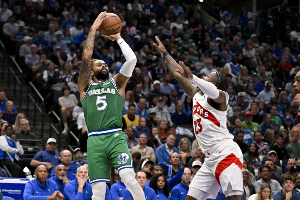 Oct 26, 2025; Dallas, Texas, USA; Dallas Mavericks guard D'Angelo Russell (5) makes a jump shot over Toronto Raptors guard Jamal Shead (23) during the second half at the American Airlines Center. Mandatory Credit: Jerome Miron-Imagn Images