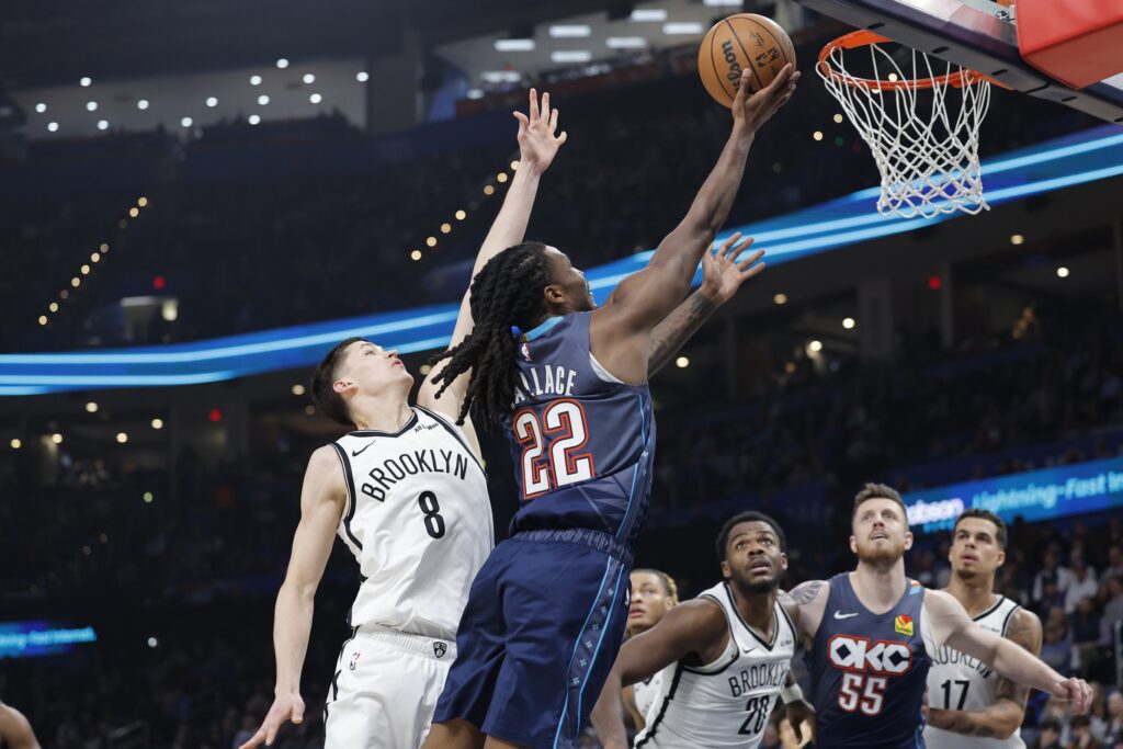 Feb 20, 2026; Oklahoma City, Oklahoma, USA; Oklahoma City Thunder guard Cason Wallace (22) shoots beside Brooklyn Nets guard Egor Dëmin (8) during the second half at Paycom Center. Mandatory Credit: Alonzo Adams-Imagn Images