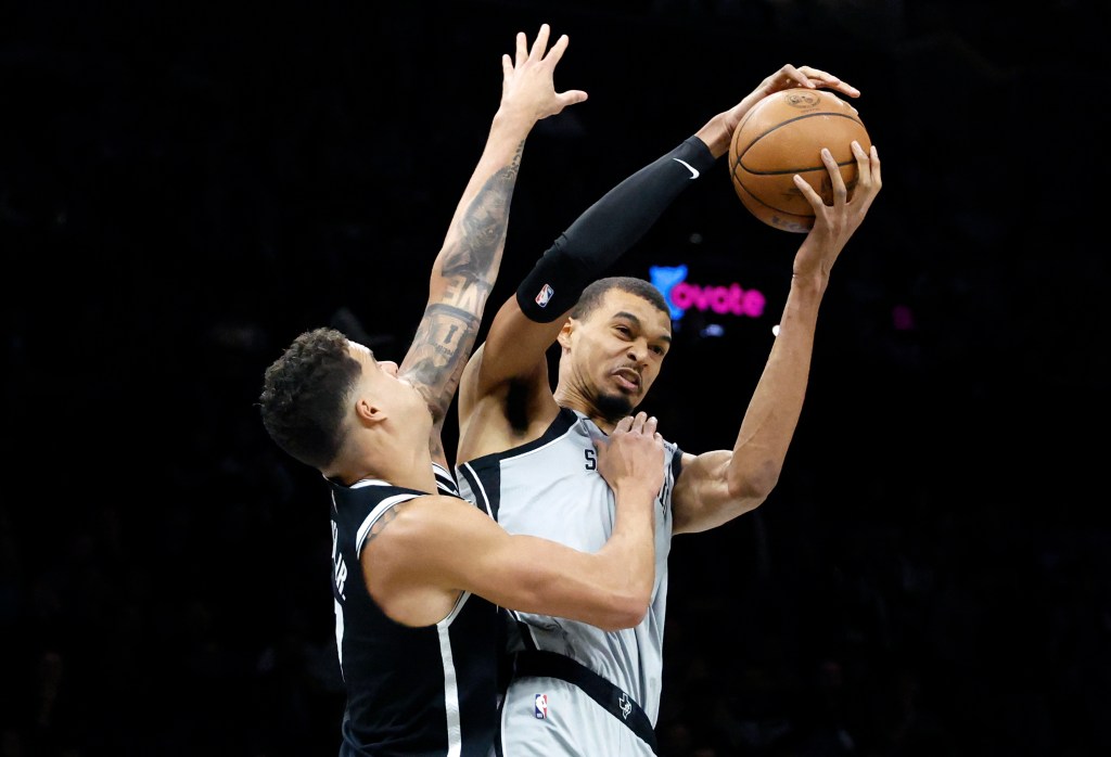 Victor Wembanyama grabs a rebound in front of Michael Porter Jr. during the Nets' home loss to the Spurs.
