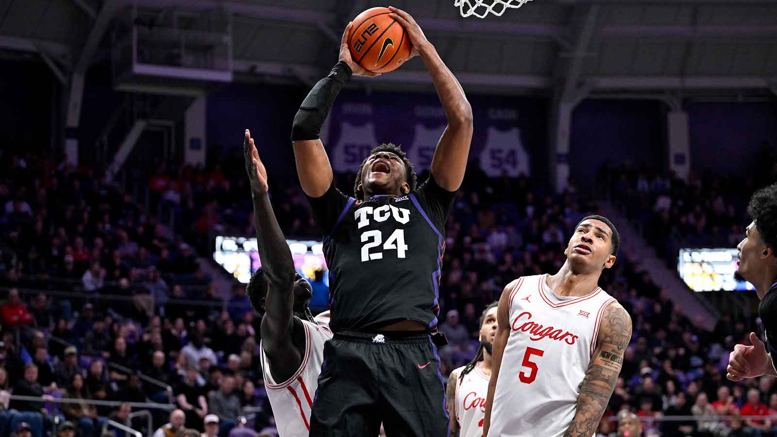 TCU Horned Frogs forward Xavier Edmonds (24) grabs a rebound over Houston Cougars forward Chris Cenac Jr. (5) during the first half at Ed and Rae Schollmaier Arena.