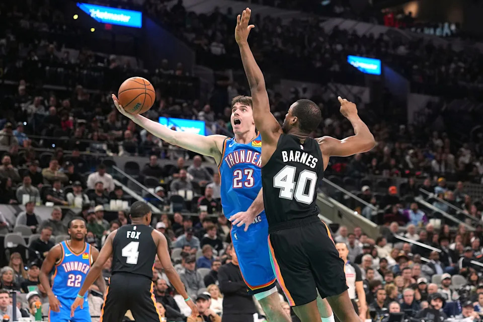 Feb 4, 2026; San Antonio, Texas, USA; Oklahoma City Thunder guard Brooks Barnhizer (23) drives to the basket against San Antonio Spurs forward Harrison Barnes (40) during the second half at Frost Bank Center. Mandatory Credit: Scott Wachter-Imagn Images