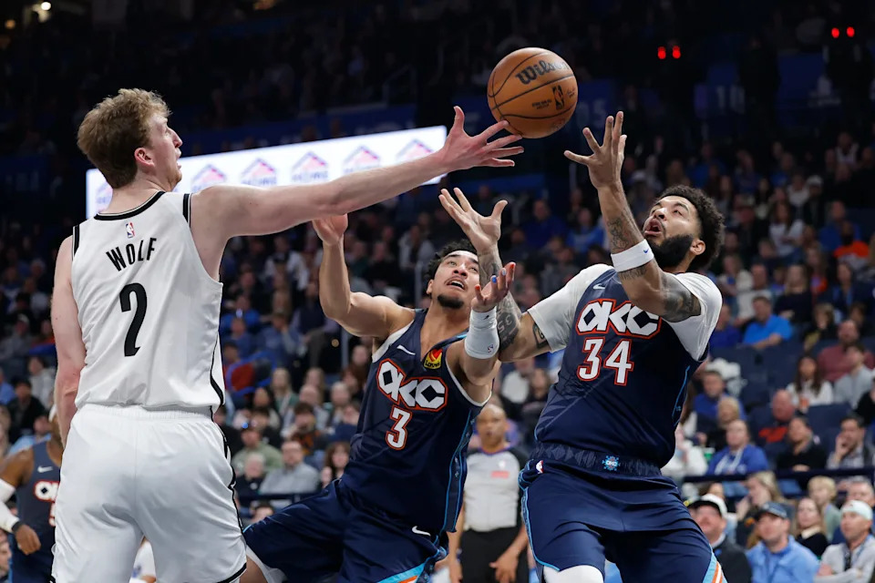 Feb 20, 2026; Oklahoma City, Oklahoma, USA; Brooklyn Nets forward Danny Wolf (2), Oklahoma City Thunder guard Jared McCain (3) and guard Kenrich Williams (34) reach for a loose ball during the second half at Paycom Center. Mandatory Credit: Alonzo Adams-Imagn Images