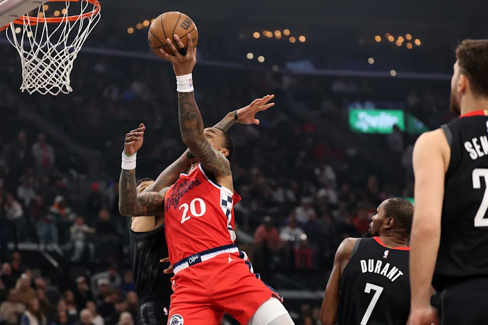 Dec 23, 2025; Inglewood, California, USA; Los Angeles Clippers forward John Collins (20) goes to the basket against Houston Rockets forward Jabari Smith Jr. (10) during the first quarter at Intuit Dome. Mandatory Credit: Kiyoshi Mio-Imagn Images