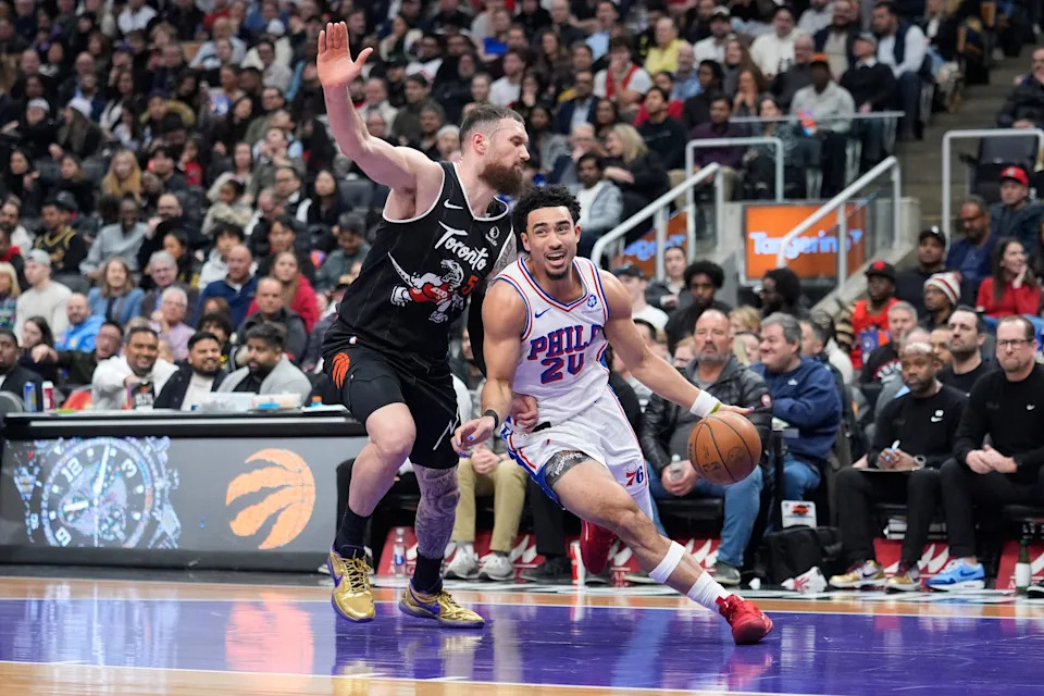Jan 12, 2026; Toronto, Ontario, CAN; Philadelphia 76ers guard Jared McCain (20) drives to the net past Toronto Raptors forward Sandro Mamukelashvili (54) during the first half at Scotiabank Arena. Mandatory Credit: John E. Sokolowski-Imagn Images