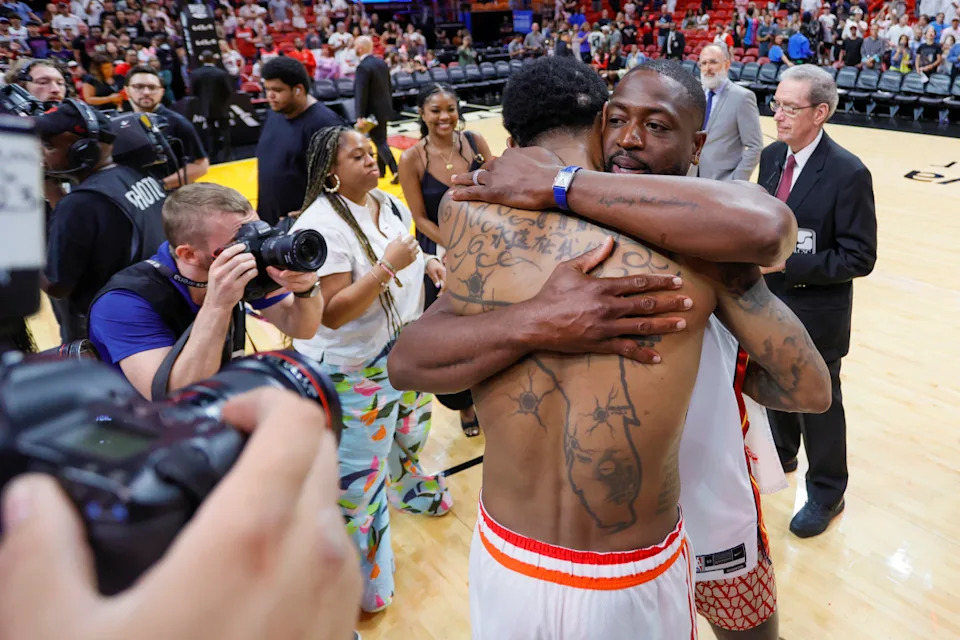 Miami Heat forward Udonis Haslem (40) hugs former Miami Heat player Dwyane Wade after playing his last regular season career game at Kaseya Center.