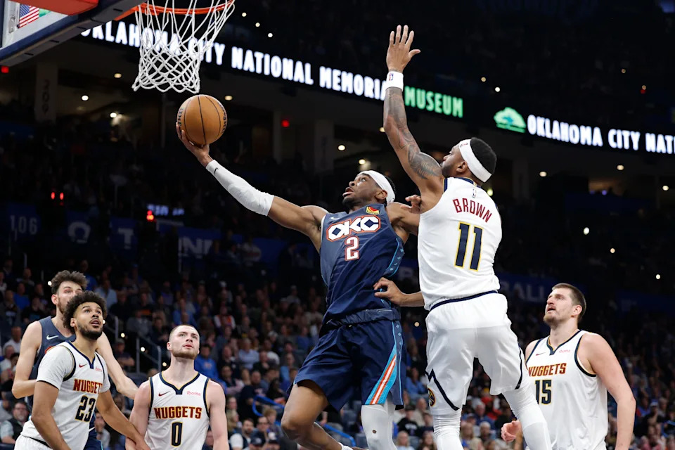 Feb 27, 2026; Oklahoma City, Oklahoma, USA; Oklahoma City Thunder guard Shai Gilgeous-Alexander (2) goes up for a basket beside Denver Nuggets guard/forward Bruce Brown (11) during the third quarter at Paycom Center. Mandatory Credit: Alonzo Adams-Imagn Images